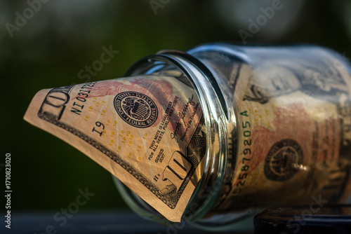 US dollar banknote saving money in glass jar. Consumption and economy