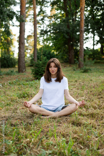 Girl meditating with her eyes open in the forest