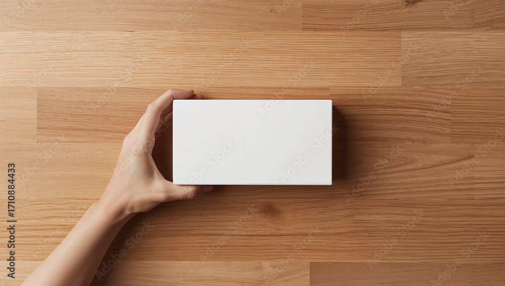 Obraz premium Hand holding white box on wood rectangular