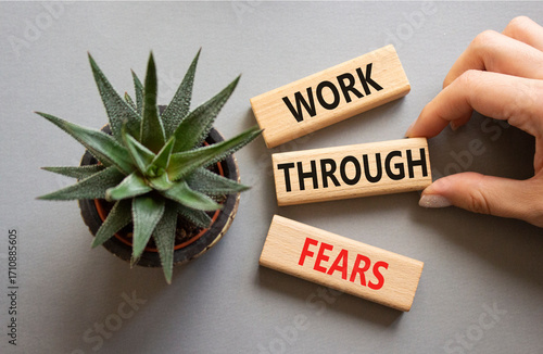 Work through fears. Wooden blocks with words Work through fears. Beautiful grey background. Businessman hand. Business and Work through fears concept. Copy space.