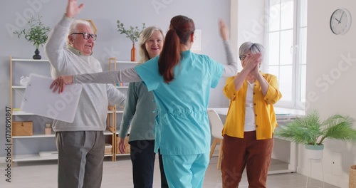 Caregiver interacts with elderly patients in a nursing home, offering high fives and embraces. Providing care, emotional support, and fostering a compassionate treatment environment.