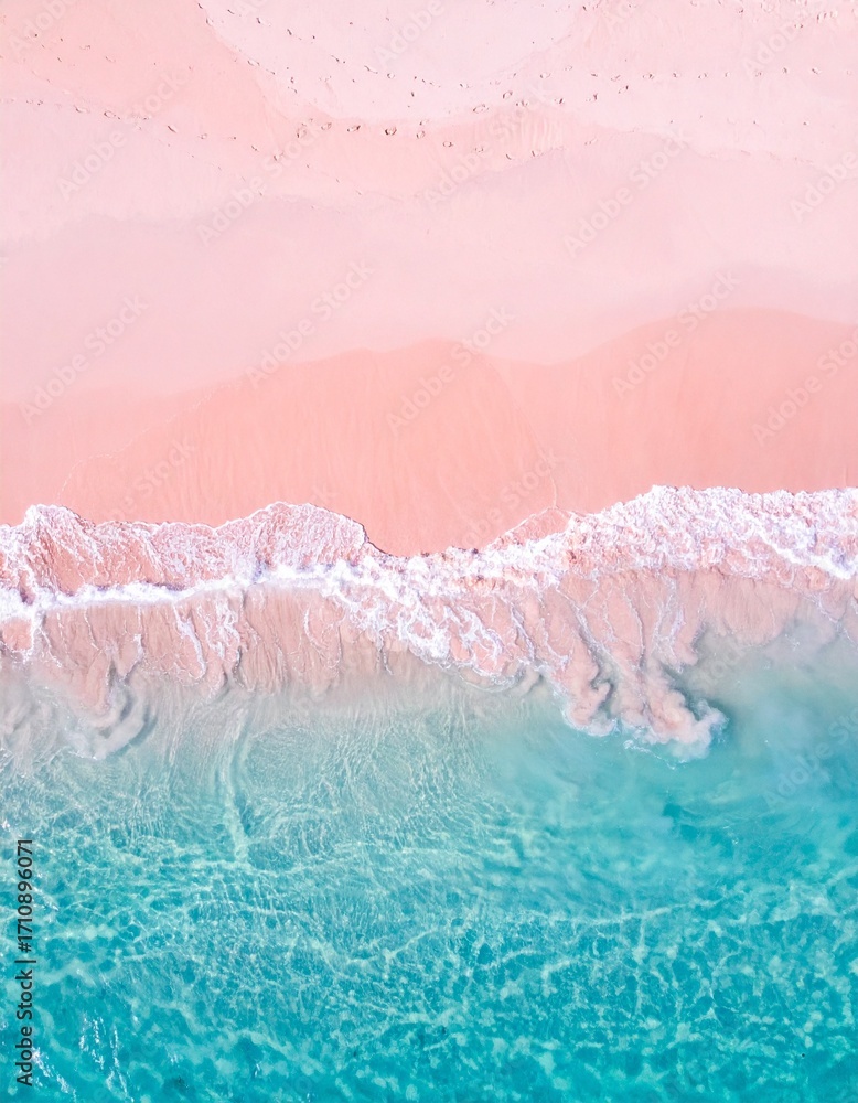 Fototapeta premium An aerial shot of a stunning pink sand beach meeting crystal clear turquoise waters, with gentle waves lapping the shore