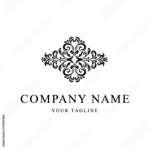 A classic black and white logo design featuring an ornate, symmetrical flourish above the text "COMPANY NAME" and "YOUR TAGLINE".