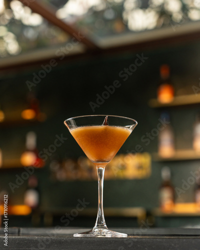 Tamarind based cocktail served in a martini class on a bar counter