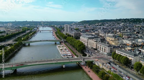 Aerial view of Rouen, France, with the Gothic Rouen Cathedral dominating the skyline, surrounded by historic half-timbered houses, the Seine River, and charming old town streets