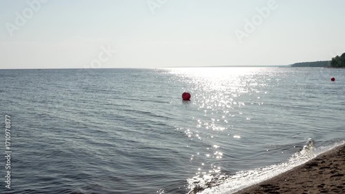 Enjoy a tranquil seaside view featuring a bright buoy floating on the calm waters of the ocean