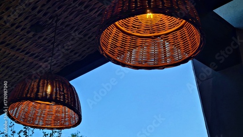 Lampshades are woven from wicker and hung on the summer veranda with lights on
