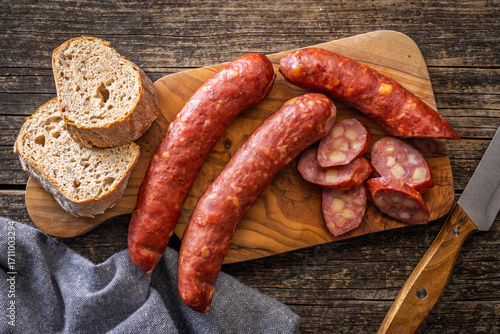 Quadro su tela Sliced smoked ​​sausage on cutting board. Top view.