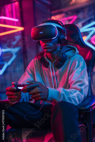 Young African American male wearing virtual reality headset, seated in gaming chair, holding controller, surrounded by colorful neon lights, immersed in gaming experience and technology