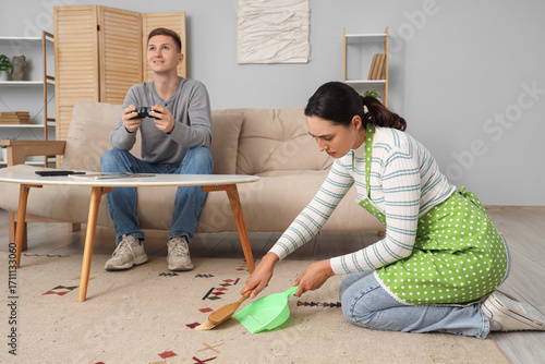 Wife sweeping carpet while ...