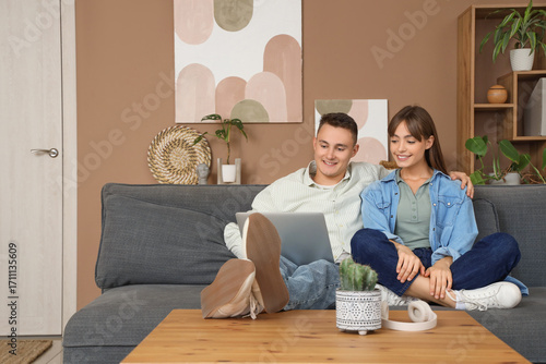 Young couple with laptop wa...