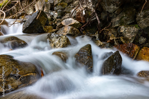 Silky Mountain Stream Cascading Over Mossy Rocks in Rugged Terrain