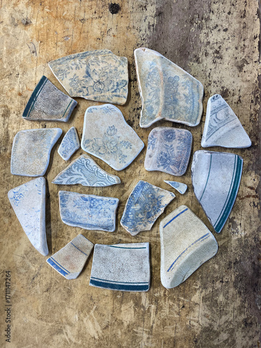 Fototapeta Collection of broken ceramics pieces arranged in a circle