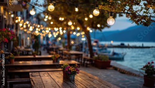 Charming waterfront restaurant terrace illuminated by warm string lights at dusk.