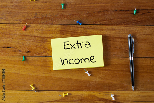 Word writing text extra income in a sticky note. Business concept.