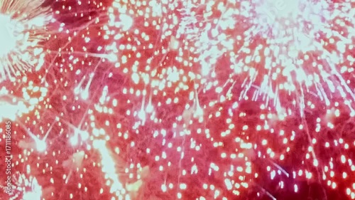 A radiant display of fireworks unfolds at night, casting a warm glow across the sky in an Eastern setting, creating a breathtaking moment of celebration.