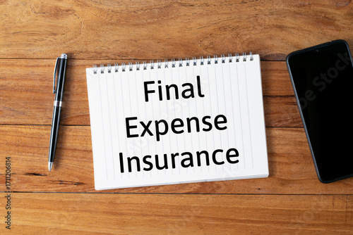 Selective focus of a pen, smartphone and notebook written with Final Expense Insurance on wooden background.