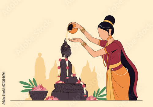 A woman pours water over a statue of Buddha in a religious ceremony.