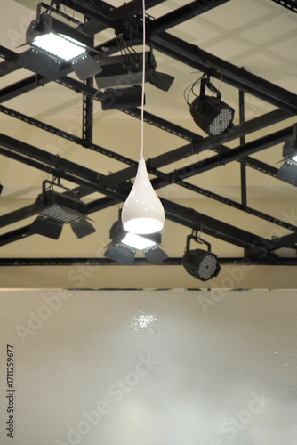 Modern White Teardrop Pendant Lamp Hanging from Industrial Ceiling Truss.