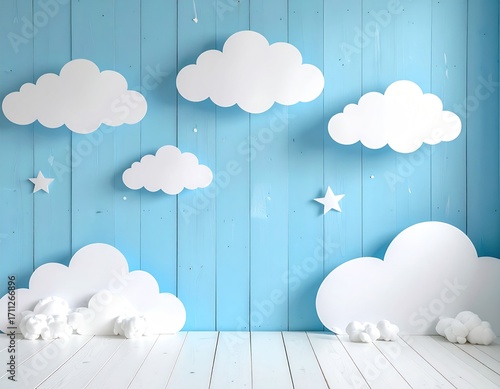 Sky-blue wooden backdrop with fluffy cloud cutouts and stars, accented with cotton ball clusters on the floor, creating a soft, dreamy scene