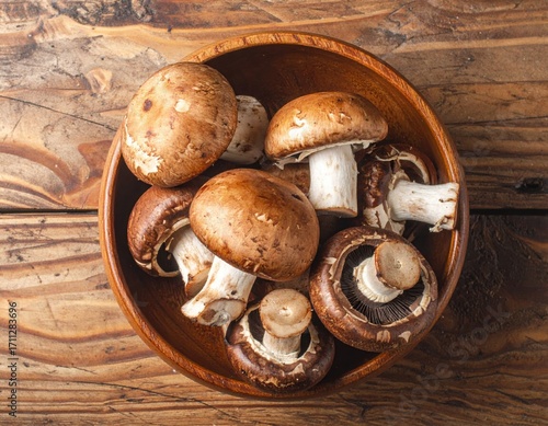 A pile of mushrooms in a bowl. on a wooden table. top view