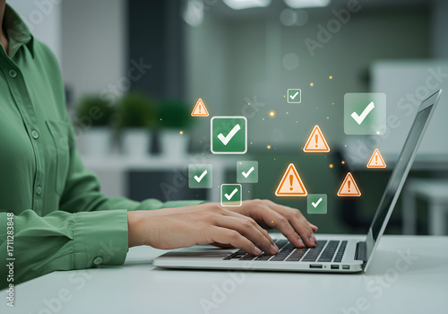 Person using laptop with check mark and warning sign graphics overlayed.