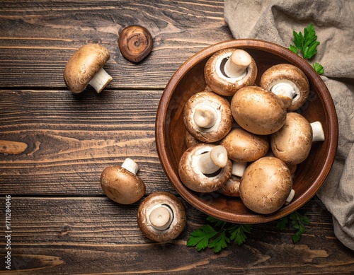 A pile of mushrooms in a bowl. on a wooden table. top view