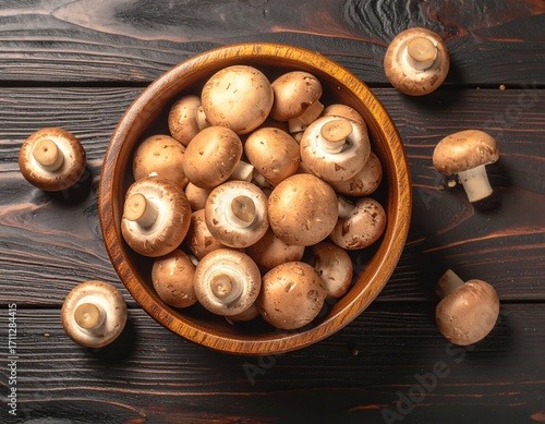 A pile of mushrooms in a bowl. on a wooden table. top view