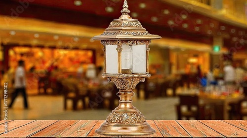 Ornate brass table lamp on wooden surface, blurred background of a bustling interior