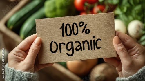 A person holds a cardboard sign that says 