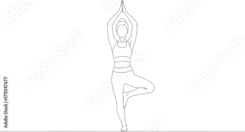 Focused person practicing a balancing yoga pose, tree pose, with hands overhead.