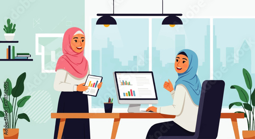 Two Muslim women in hijab working in an office with computer and tablet.