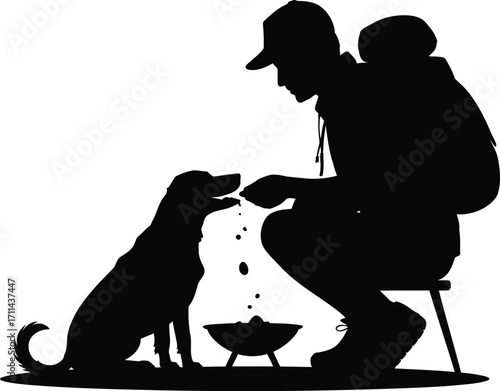 Man feeding his dog while camping in the wilderness silhouette