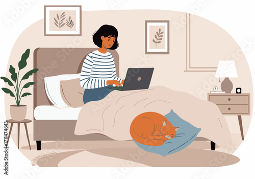 A woman sits in bed working on a laptop while her ginger cat sleeps curled up on a pillow.