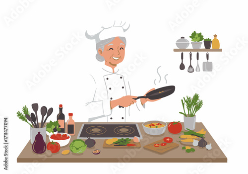 Smiling elderly female chef in uniform holds a frying pan over a stove, surrounded by fresh vegetables and cooking ingredients on a wooden counter.