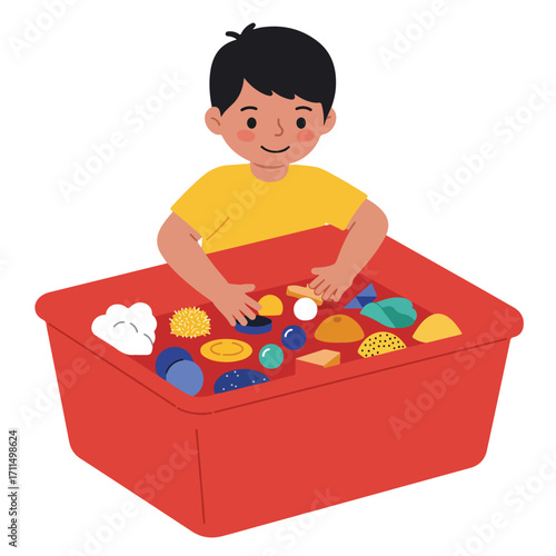 Young boy smiling and playing in a bin with toys of different shapes and textures