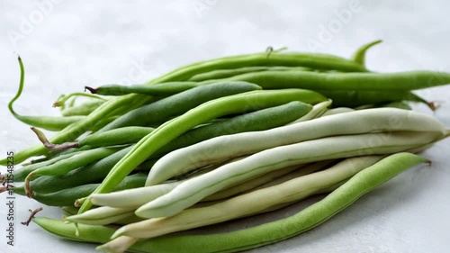 Fresh green and white beans on a light background