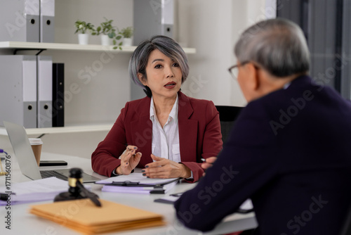 Asian adult woman lawyer legal counsel client professional consultation office setting business meeting discussion gavel