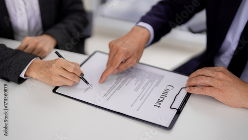 Adult Asian hands signing legal contract paperwork at a formal office meeting Business professionals finalize agreement document