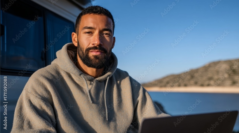 Obraz premium Man using laptop at beach.