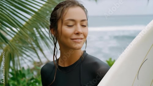 A woman with wet hair is smiling and holding a surfboard. Concept of happiness and excitement, as the woman is ready to enjoy her time at the beach