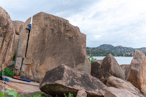 A rock climber climbing through the crack in Hampi.