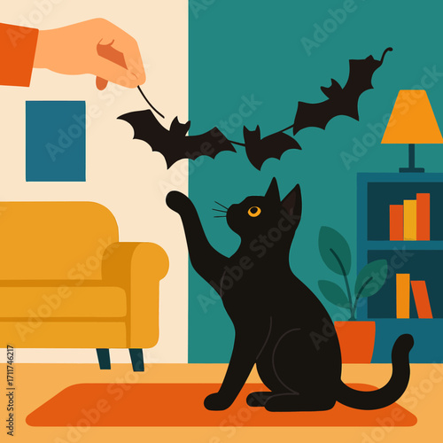 A playful black cat joyfully reaches for a string of decorative bats, held by a human hand, creating a festive Halloween atmosphere indoors.