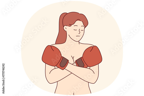 Woman suffering from domestic violence and male dominance covers bare chest with boxing gloves. Problem of domestic violence in different communities causes depression in feminist girl