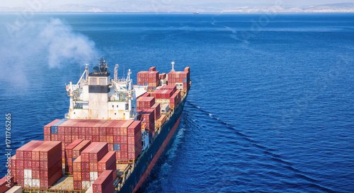Fototapeta Naklejka Na Ścianę i Meble -  Aerial rear view of a large, industrial container cargo ship sailing over the ocean with copy space