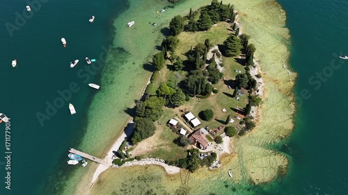 Wallpaper Mural Aerial view in 4K drone video of Isola di San Biagio, Lake Garda, Italy, surrounded by turquoise waters. Torontodigital.ca
