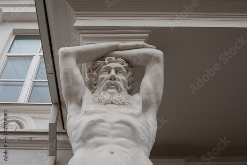 Entrance of Tyszkiewicz manor featuring Atlantes sculptures in Vilnius, Lithuania