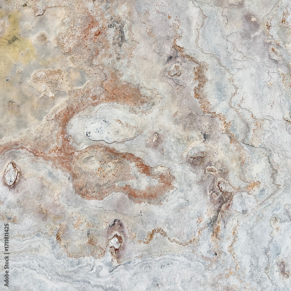 Naklejka premium Natural stone texture with earthy tones of gray and rusty orange, showcasing rough surface patterns and organic details, ideal for backgrounds or design