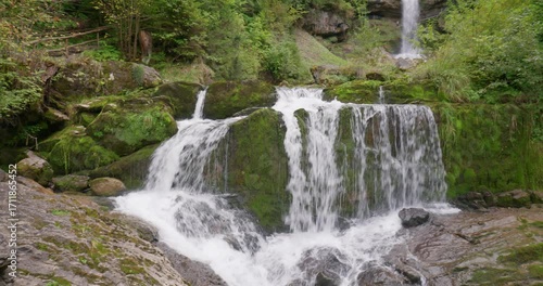Giessbach falls in Brienz, Switzerland, September 14, 2025. Famous waterfall cascading in the forested ravine above lake Brienz. Overcast summer day, real time, panning shot
