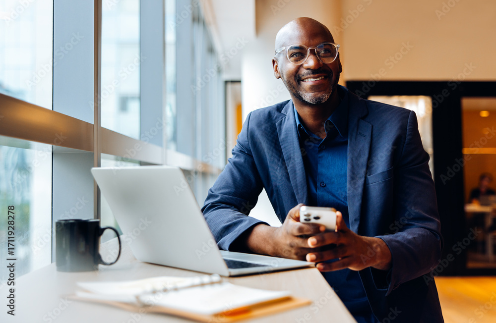 custom made wallpaper toronto digitalSmiling businessman using smartphone at a desk with laptop and notebook